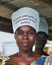 Eine Frau trägt ein Schild mit der Aufschrift women and girls are important in the society.