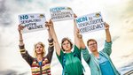 Drei Frauen halten Demo-Schilder gegen sexualisierte Kriegsgewalt in die Luft.